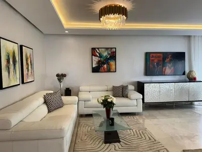 a living room with two couches and a chandelier at Rabat Atlantic Océan in Rabat