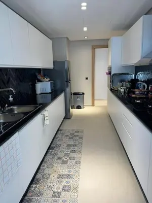 a kitchen with white cabinets and a tile floor at Rabat Atlantic Océan in Rabat