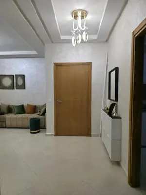 a living room with a wooden door and a couch at appartement luxe dt5 in Mohammedia