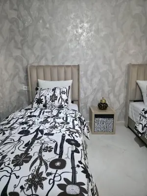 a bedroom with a bed with a black and white comforter at appartement luxe dt5 in Mohammedia