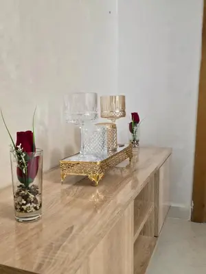a wooden table with a vase of flowers and a vase of roses at appartement luxe dt5 in Mohammedia