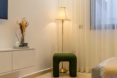 a bedroom with a green chair and a lamp at Luxury Studio Apartment - Maarif Near CFC & Downtown in Casablanca