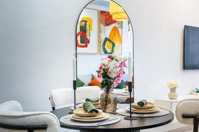 a table with a vase of flowers and a mirror at Luxury Studio Apartment - Maarif Near CFC & Downtown in Casablanca