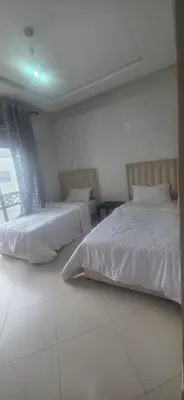 a bedroom with two beds and a window at luxury apartment DT2 in Mohammedia