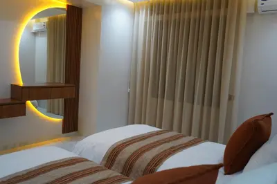 two beds in a hotel room with a mirror at Appartamento di lusso nel cuore di Rabat in Rabat