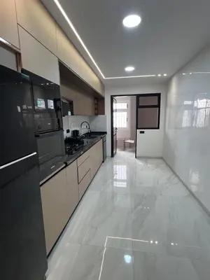 a large kitchen with black appliances and white cabinets at Appartamento di lusso nel cuore di Rabat in Rabat