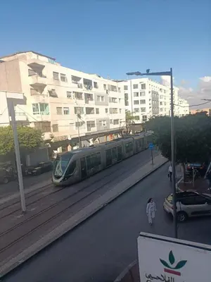 a train is on the tracks near a building at Appartamento di lusso nel cuore di Rabat in Rabat