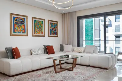 a living room with a white couch and a table at Luxury 2BR Pearl of Agdal Near Agdal Train Station in Rabat