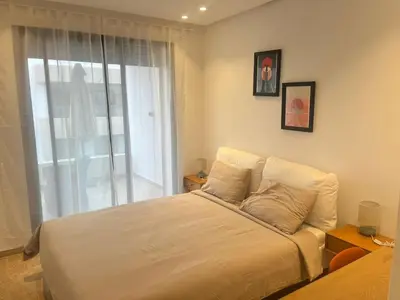 a bedroom with a large bed with a window at Apartment Dar Bouazza with swimming pools and 2 bedrooms in Casablanca