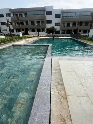 a swimming pool in front of a building at Apartment Dar Bouazza with swimming pools and 2 bedrooms in Casablanca