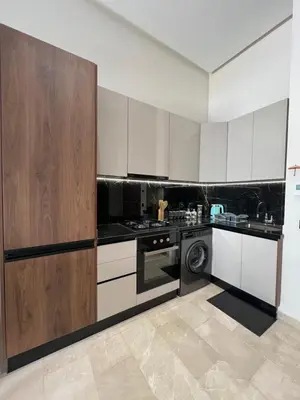 a kitchen with white cabinets and a washing machine at A Suites in Casablanca