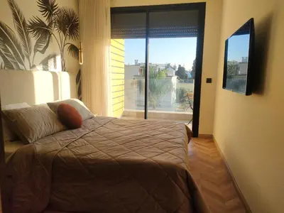 a bedroom with a bed and a view of a balcony at Studio haut standing in Casablanca