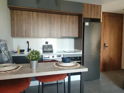 a kitchen with wooden cabinets and a stainless steel refrigerator at Studio haut standing in Casablanca