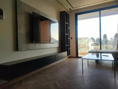 a living room with a table and a large window at Studio haut standing in Casablanca
