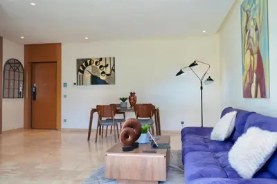 a living room with a blue couch and a table at Casablanca Finance City 2Bdr in Casablanca