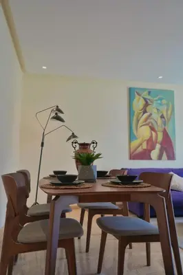 a dining room table with chairs and a lamp at Casablanca Finance City 2Bdr in Casablanca