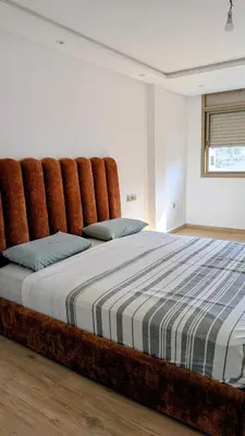 a large bed with a large headboard in a bedroom at appartement en bord de mer Rabat in Rabat