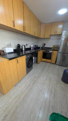 a large kitchen with wooden cabinets and a dishwasher at appartement en bord de mer Rabat in Rabat