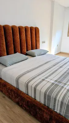 a large bed with a large wooden headboard at appartement en bord de mer Rabat in Rabat