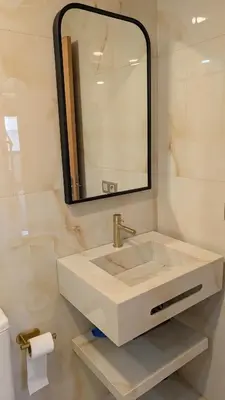 a white bathroom with a sink and a mirror at appartement en bord de mer Rabat in Rabat