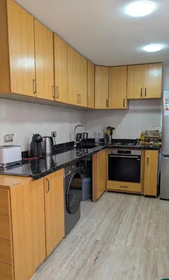 a large kitchen with wooden cabinets and appliances at appartement en bord de mer Rabat in Rabat