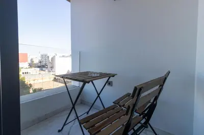 a table and a bench on a balcony with a window at Modern Studio in Maarif 16 with Free Private Parking in Casablanca