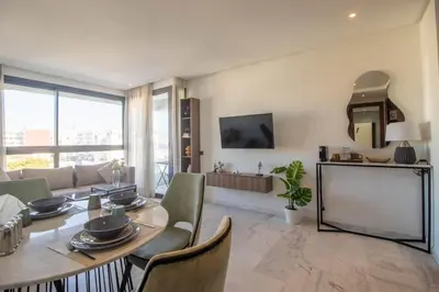 a living room with a table and chairs and a couch at Modern Studio in Maarif 16 with Free Private Parking in Casablanca