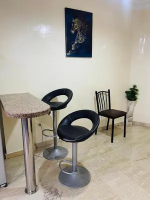 a room with two bar stools and a table and chairs at Résidence TPM in Casablanca