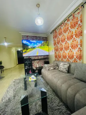 a living room with a couch and a large screen at Résidence TPM in Casablanca