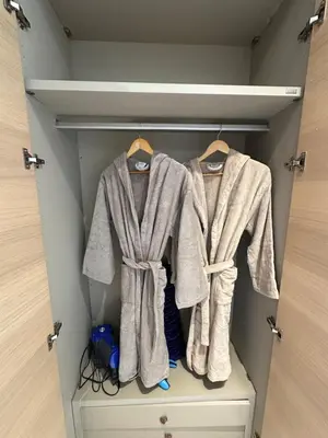 two robes hanging on hangers in a closet at Hay Riad Sunset Studio Stadium View , 5 mind a pied stade moulay abdelah in Rabat