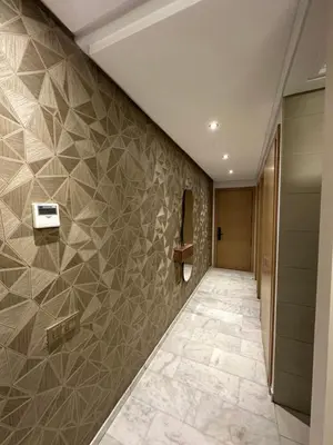 a hallway with a tile accent wall and ailed hallway at Hay Riad Sunset Studio Stadium View , 5 mind a pied stade moulay abdelah in Rabat