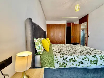 a bedroom with a bed with a green bedspread at Beau studio a CFC in Casablanca