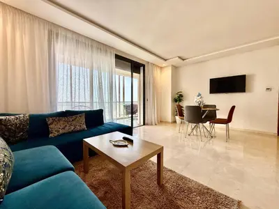 a living room with a blue couch and a table at Beau studio a CFC in Casablanca