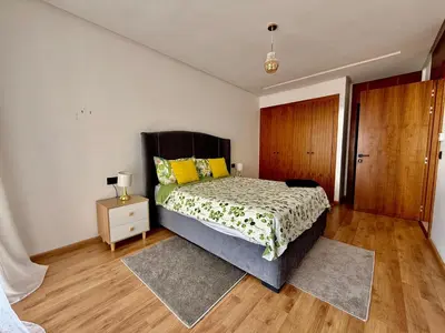 a bedroom with a bed with yellow pillows and a night stand at Beau studio a CFC in Casablanca
