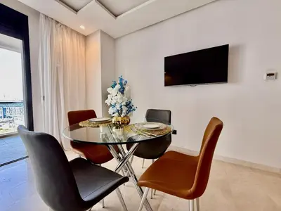 a dining room with a glass table and chairs at Beau studio a CFC in Casablanca