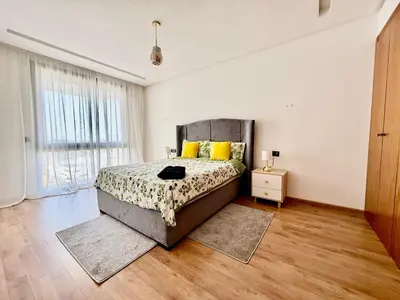 a bedroom with a bed and a large window at Beau studio a CFC in Casablanca