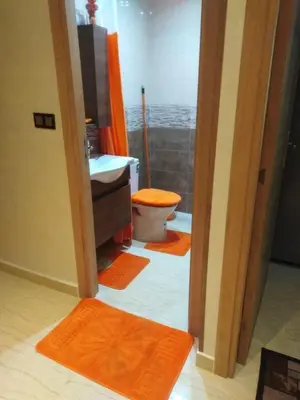 a bathroom with a toilet and a sink and orange mats at Beautiful apartment in Hay Al Qods Bernoussi in Casablanca