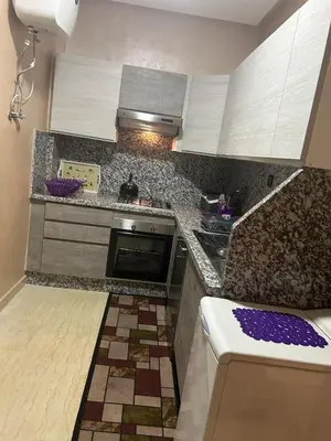 a kitchen with white cabinets and a counter top at Beautiful apartment in Hay Al Qods Bernoussi in Casablanca