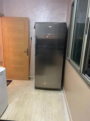 a black refrigerator in a room with a window at Beautiful apartment in Hay Al Qods Bernoussi in Casablanca