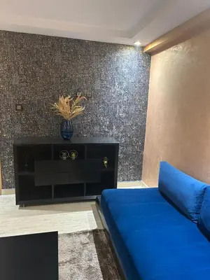 a blue couch in a room with a wall at Beautiful apartment in Hay Al Qods Bernoussi in Casablanca