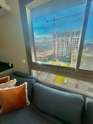 a couch in a room with a large window at Charming Studio in Zenata Eco-city, Pool and Sea View in Aïn Harrouda