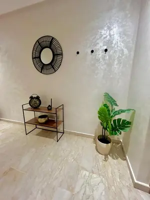 a room with a mirror and a potted plant at Charming Studio in Zenata Eco-city, Pool and Sea View in Aïn Harrouda