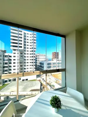a room with a white table and a large window at Charming Studio in Zenata Eco-city, Pool and Sea View in Aïn Harrouda