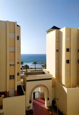 a view of two buildings with the ocean in the background at Elegant apartment with sea view in Rabat