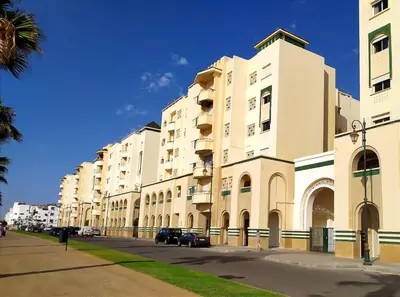 a large white building with cars parked on a street at Elegant apartment with sea view in Rabat