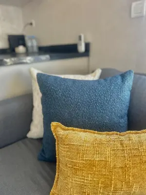 a couch with two pillows and a blue pillow at Luxury Studio in a secured residence in Aïn Harrouda