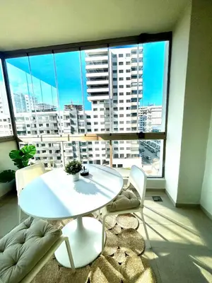 a white table and chairs in a room with a large window at Luxury Studio in a secured residence in Aïn Harrouda