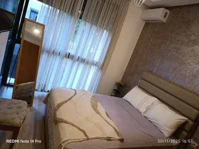 a bedroom with a bed and a large window at Océane palm in Casablanca