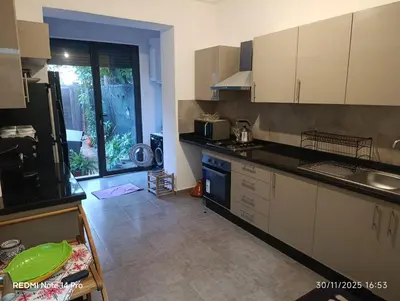 a kitchen with white cabinets and a large window at Océane palm in Casablanca