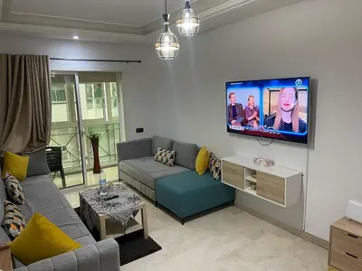 a living room with a couch and a tv on a wall at Lovely place in Casablanca